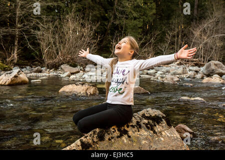 Neun Jahre altes Mädchen mit Begeisterung und Freude warf ihre Arme breit, in Snoqualmie River in North Bend, Washington Stockfoto