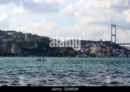 Drei Schiffer stehend auf einem Boot im Bosporus, Istanbul. Rumeli Hisari, zweiten Bosporus-Brücke (Fatih Sultan Mehmet Br.) hinter Stockfoto