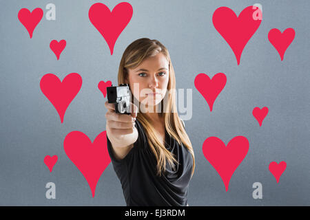Zusammengesetztes Bild der Femme Fatale zeigenden Waffe auf Kamera Stockfoto