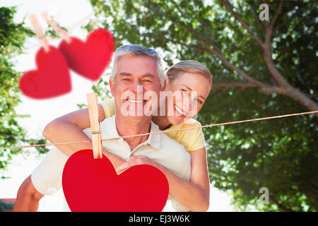 Zusammengesetztes Bild der senior glücklich mit seiner Partnerin eine Huckepack Stockfoto