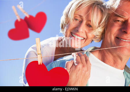 Zusammengesetztes Bild der senior glücklich mit seiner Partnerin eine Huckepack Stockfoto