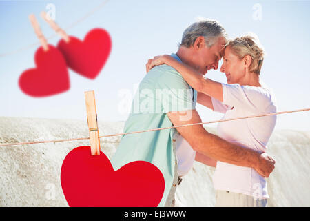 Zusammengesetztes Bild von glücklichen senior paar umarmt auf dem pier Stockfoto