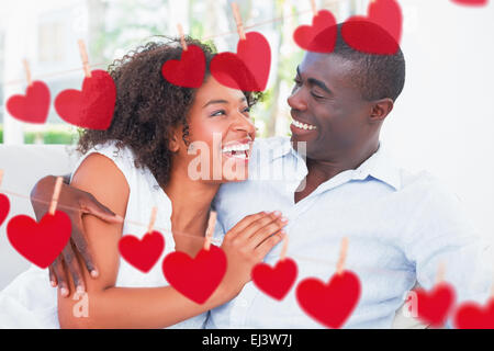 Zusammengesetztes Bild attraktives Paar auf der Couch kuscheln Stockfoto