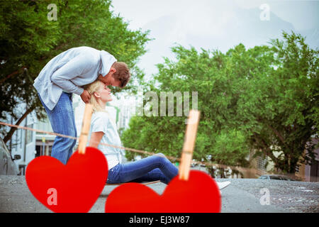 Zusammengesetztes Bild hippe junge blonde sitzen auf Skateboard mit Freund Stirn küssen Stockfoto