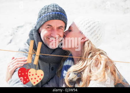 Zusammengesetztes Bild attraktives Paar am Strand in warme Kleidung Stockfoto