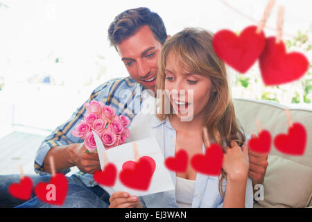 Zusammengesetztes Bild der liebende Paar mit Blumen und Grußkarte Stockfoto