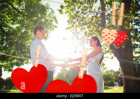 Zusammengesetztes Bild der liebende junge Paar Hand in Hand im park Stockfoto