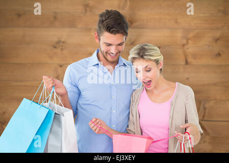Zusammengesetztes Bild attraktives junges Paar halten Einkaufstaschen Stockfoto