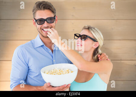 Zusammengesetztes Bild von glücklichen jungen Paar 3d Brille Essen popcorn Stockfoto