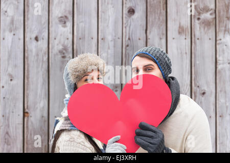 Zusammengesetztes Bild attraktives junges Paar in warme Kleidung mit roten Herzen Stockfoto