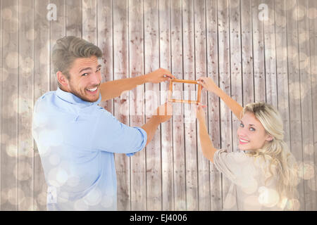 Zusammengesetztes Bild attraktives junges Paar hängen einen Rahmen Stockfoto