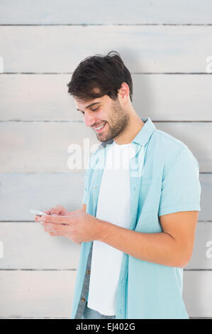 Zusammengesetztes Bild glücklich legerer Mann senden einer Textnachricht Stockfoto