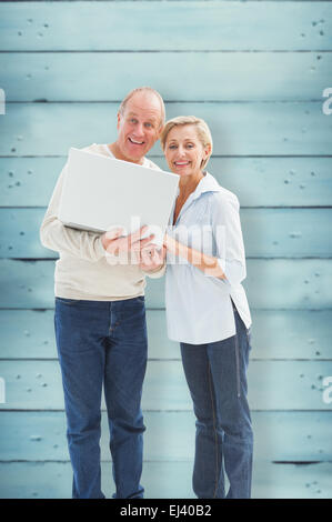 Montagebild von älteres paar lächelnd in die Kamera mit laptop Stockfoto