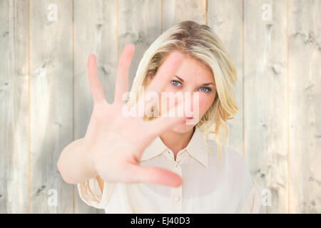 Zusammengesetztes Bild hübsche Blondine an Hand bis zu Kamera Stockfoto