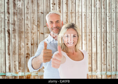 Zusammengesetztes Bild des Lächelns paar Daumen zusammen auftauchen Stockfoto