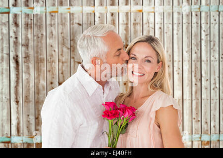 Zusammengesetztes Bild von liebevollen Mann seine Frau auf die Wange küssen, mit Rosen Stockfoto