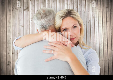 Zusammengesetztes Bild unglücklich Blondine umarmt ihr Ehemann Stockfoto