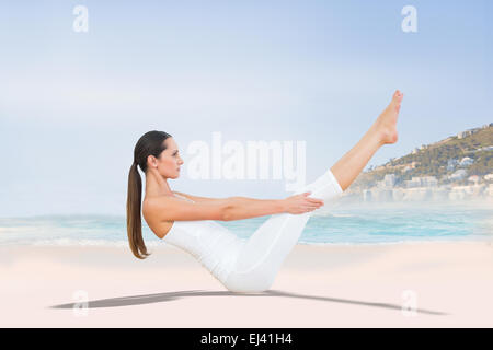 Zusammengesetztes Bild durchtrainierten Frau tun, die Boot-Pose am Strand Stockfoto