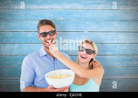 Zusammengesetztes Bild von glücklichen jungen Paar 3d Brille Essen popcorn Stockfoto