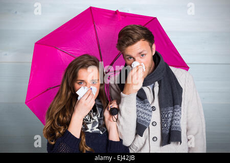 Zusammengesetztes Bild des Paares, die Nase weht, Regenschirm mit gedrückter Stockfoto