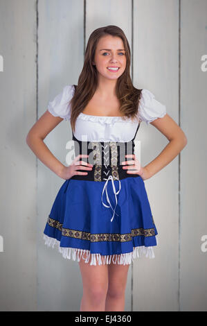 Zusammengesetztes Bild des Oktoberfest Mädchen lächelnd in die Kamera Stockfoto