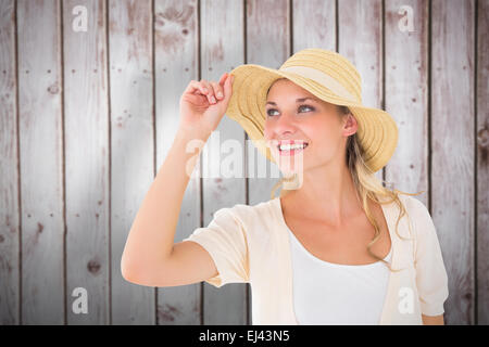 Zusammengesetztes Bild der attraktive junge blonde lächelnd in Sonnenhut Stockfoto