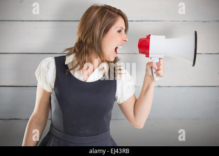Zusammengesetztes Bild der Geschäftsfrau durch Megaphon schreien Stockfoto