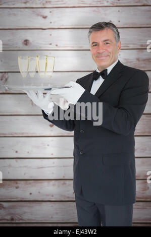 Zusammengesetztes Bild von lächelnden Kellner Holding Tablett mit Gläsern mit Sekt Stockfoto
