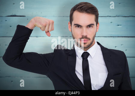 Zusammengesetztes Bild der Geschäftsmann anspannen Arm Muskel und Blick in die Kamera Stockfoto