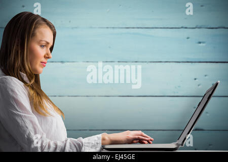 Zusammengesetztes Bild der Geschäftsfrau auf ihrem Laptop tippen Stockfoto