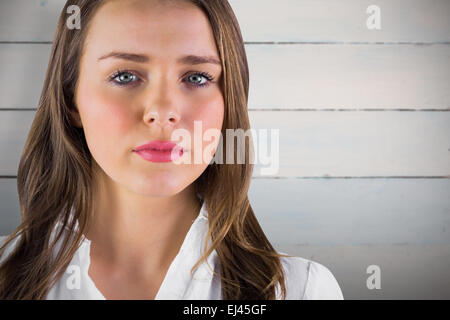 Zusammengesetztes Bild der ernste junge Frau in weißem Hemd Stockfoto