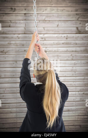 Zusammengesetztes Bild der Geschäftsfrau ziehen an einer Kette Stockfoto