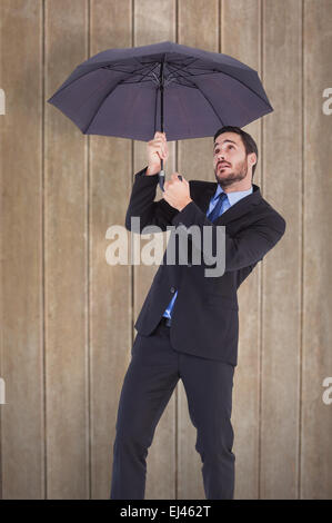 Zusammengesetztes Bild der Geschäftsfrau im Anzug hält Regenschirm Stockfoto