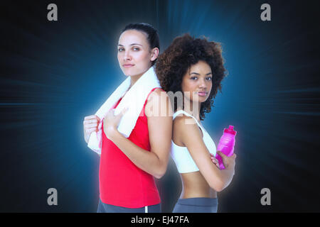 Zusammengesetztes Bild von Fit Frauen stehend mit Wasserflasche und Handtuch Stockfoto