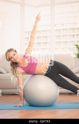 Zusammengesetztes Bild glücklich Fit Blondine tun Seite Plank mit Gymnastikball Stockfoto