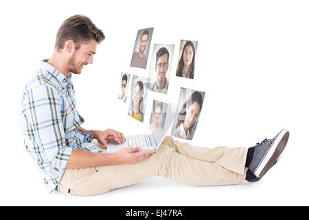 Zusammengesetztes Bild hübscher junger Mann sitzt mit Laptop Stockfoto