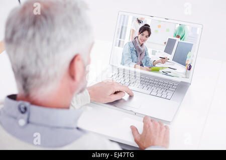 Zusammengesetztes Bild von hinten Nahaufnahme von einem grauen Haaren Mann mit Laptop am Schreibtisch Stockfoto