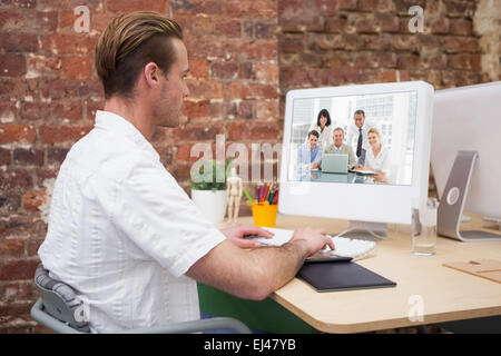 Zusammengesetztes Bild glücklich Geschäftsleute versammelt um einen Blick in die Kamera laptop Stockfoto