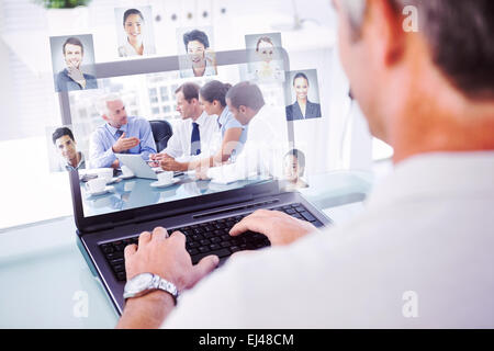 Zusammengesetztes Bild Mann mit grauem Haar auf Laptop tippen Stockfoto