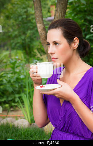 Schöne junge Frau, die leckeren Kaffeetrinken im freien Stockfoto