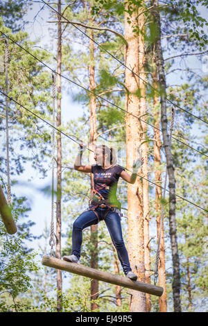 13. Juli 2014, Russland, Sankt-Petersburg, adventure Park "Norwegian Wood". Junge mutige Frau in ein Abenteuer-Seilpark Klettern Stockfoto