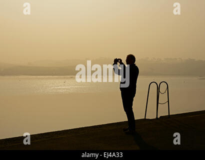 Silhouette des Menschen fotografieren auf dem Kai, Appledore, Devon, England UK Stockfoto
