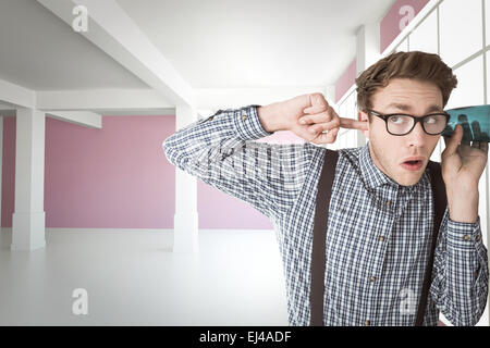 Zusammengesetztes Bild von geeky Geschäftsmann Abhören mit Tasse Stockfoto