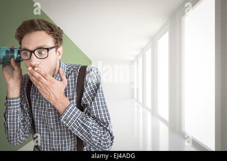 Zusammengesetztes Bild von geeky Geschäftsmann Abhören mit Tasse Stockfoto