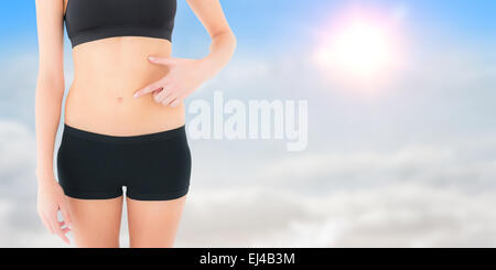 Zusammengesetztes Bild von Closeup Mittelteil einer Fit Frau mit Hand auf Bauch Stockfoto