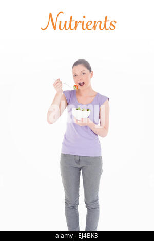 Nährstoffen gegen umwerfende Frau essen eine Schale mit Salat im stehen Stockfoto