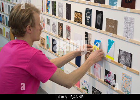 London, UK. 21. März 2015. RCA-Studenten helfen, um die Kunstwerke zu holen. Viele Kunstliebhaber in der Warteschlange an der Royal College of Art Dyson Builing durch die Nacht, erster in der Linie für den Stewarts Recht RCA Geheimnis Postkarte Vertrieb sein die heute beginnt. RCA-Geheimnis ist eine jährliche Spendenaktion der Postkarte Größe Arworks um Geld für die RCA Fine Art Student Award Fund. In diesem Jahr 3.000 sind Kunstwerke, darunter Arbeiten von berühmten Künstlern wie Bob & Roberta Smith, Paula Rego und Nick Park - die anonym angezeigt werden - zum Verkauf. Die RCA hofft, mehr als 120.000 GBP, junge Künstler zu unterstützen erhöhen. P Stockfoto