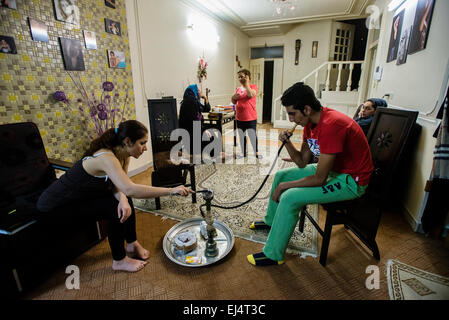 Cousins von Parsa, Informatik-Student, Rauch Qelyan nach dem Abendessen, traditionelle Art der Unterhaltung in den iranischen Familien, während seine Tante Fara sprechen mit ihrer Schwester in Deutschland, Isfahan, Iran Stockfoto