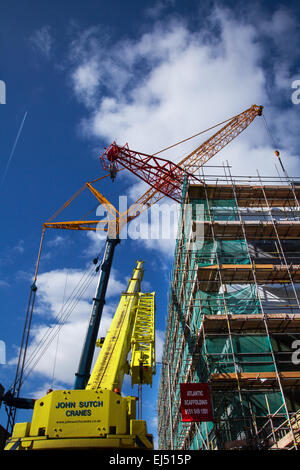 Studentenunterkunft in Liverpool, Merseyside, Großbritannien 21. März 2015. 40m hoher roter Turmdrehkran, der auf der Baustelle eines großen Komplexes von Nordic Construction verwendet wurde, der entfernt wird. Der Standort in der Hope Street ist ein Studentenzentrum mit 339 Zimmern, einem Fitnessstudio, einem Kino, Bars und Restaurants. Der Kran wird mit einem noch größeren 750 Tonnen Luffer Crane mit hydraulischen Wippauslegern demontiert (wird in engen städtischen Arbeitsräumen verwendet, wenn der Abstand zum Drehen des Jib nicht ausreicht), Einer der größten Krane dieser Art in Europa und einer von nur drei in Großbritannien. Stockfoto