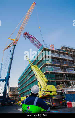 Studentenunterkunft in Liverpool, Merseyside, Großbritannien 21. März 2015. 40m hoher roter Turmdrehkran, der auf der Baustelle eines großen Komplexes von Nordic Construction verwendet wurde, der entfernt wird. Der Standort in der Hope Street ist ein Studentenzentrum mit 339 Zimmern, einem Fitnessstudio, einem Kino, Bars und Restaurants. Der Kran wird mit einem noch größeren 750 Tonnen Luffer Crane mit hydraulischen Wippauslegern demontiert (wird in engen städtischen Arbeitsräumen verwendet, wenn der Abstand zum Drehen des Jib nicht ausreicht), Einer der größten Krane dieser Art in Europa und einer von nur drei in Großbritannien. Stockfoto